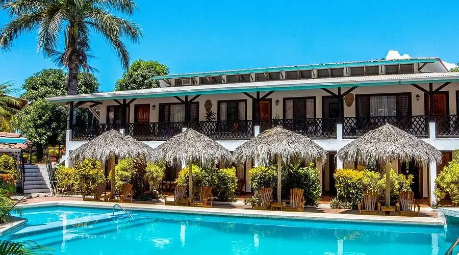 Hôtel tropical avec piscine, jardin et hébergements chaleureux.